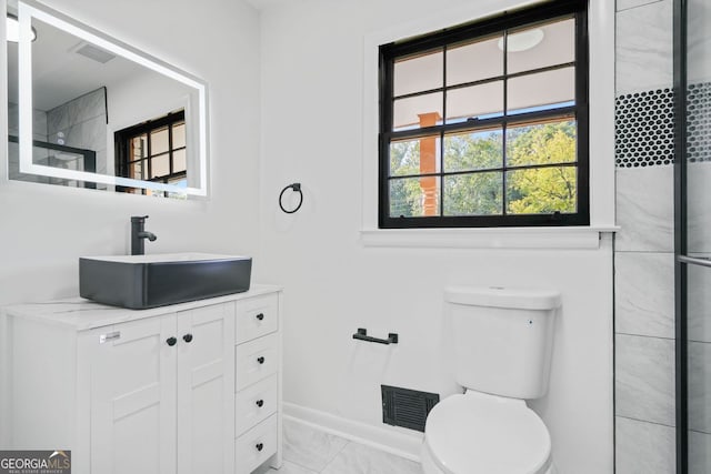 bathroom with vanity, a shower, and toilet