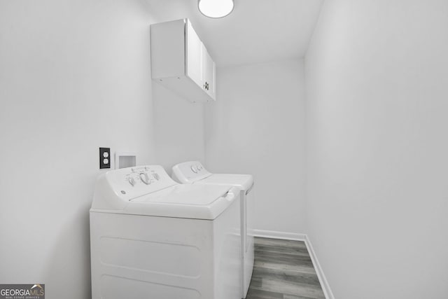 laundry room with hardwood / wood-style flooring, cabinets, and washer and clothes dryer