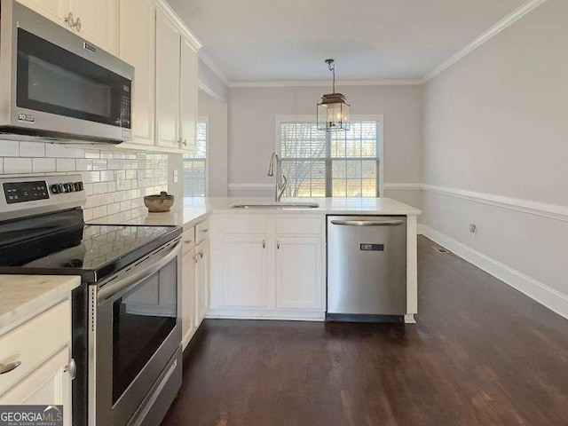 kitchen featuring sink, hanging light fixtures, stainless steel appliances, ornamental molding, and white cabinets