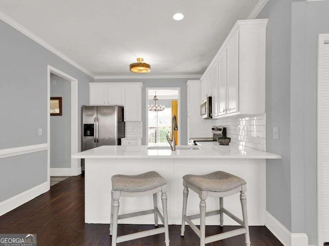 kitchen featuring white cabinetry, appliances with stainless steel finishes, kitchen peninsula, and sink