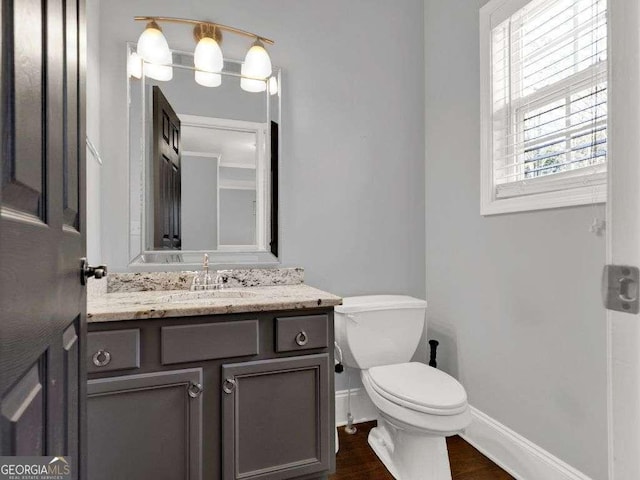 bathroom featuring vanity, hardwood / wood-style floors, and toilet