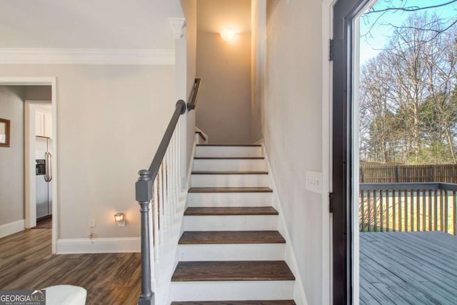 stairway featuring ornamental molding and wood-type flooring