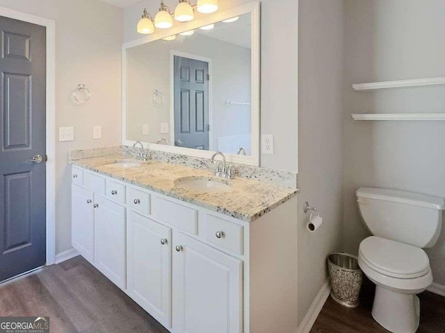 bathroom featuring vanity, wood-type flooring, and toilet