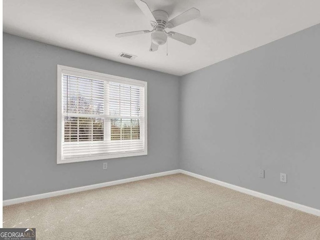 spare room featuring ceiling fan and carpet floors