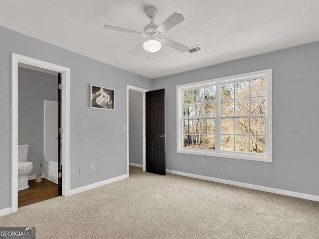 unfurnished bedroom with light carpet, ensuite bath, and ceiling fan