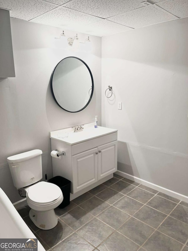 bathroom featuring vanity, a paneled ceiling, tile patterned floors, and toilet