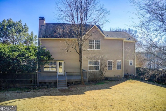 rear view of property with a lawn and a deck