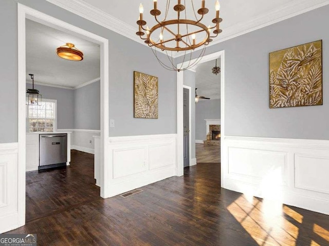 unfurnished dining area featuring ornamental molding, dark hardwood / wood-style floors, ceiling fan, and a fireplace