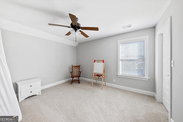 sitting room with baseboards, visible vents, light colored carpet, lofted ceiling, and ceiling fan