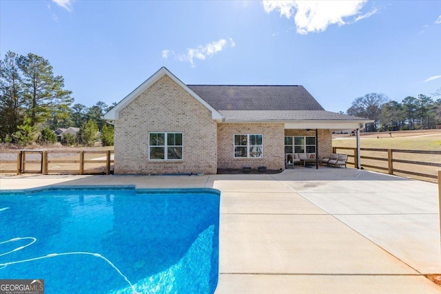 view of swimming pool featuring a patio area, fence, and a fenced in pool