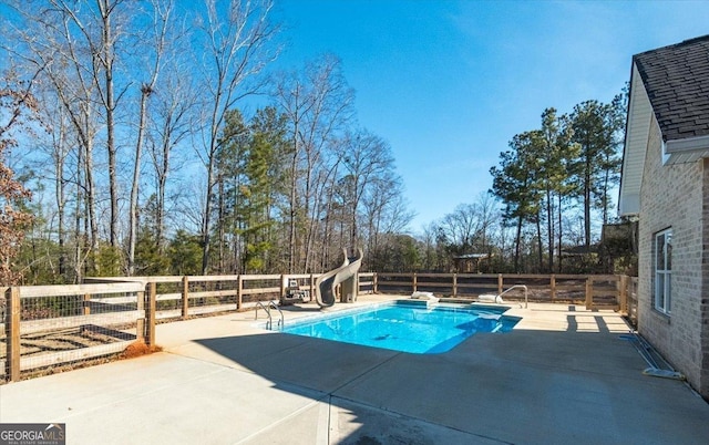 view of pool with a water slide and a patio