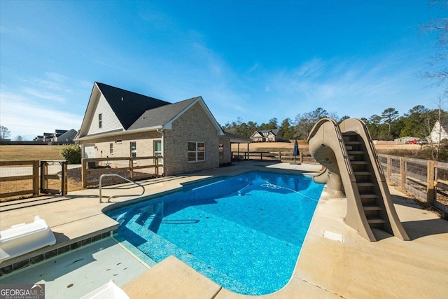 view of pool featuring a water slide and a patio area