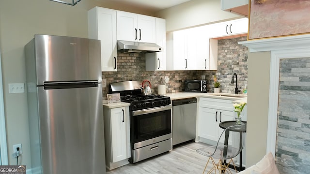 kitchen with sink, decorative backsplash, stainless steel appliances, and white cabinets