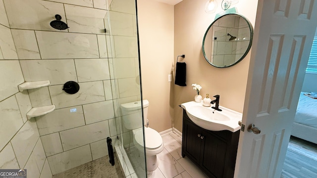 bathroom with vanity, a tile shower, and toilet