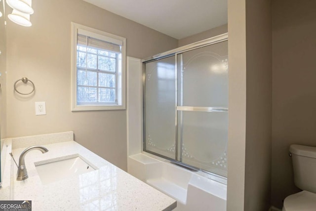 bathroom with vanity, toilet, and a shower with shower door