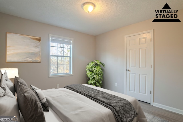 bedroom featuring wood-type flooring and a textured ceiling