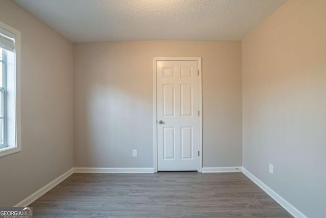 empty room featuring a textured ceiling and light wood-type flooring