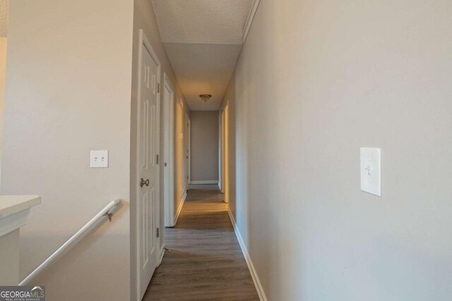 hallway featuring dark hardwood / wood-style flooring and a textured ceiling