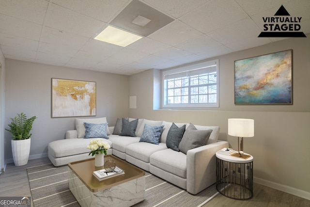 living room with wood-type flooring and a drop ceiling