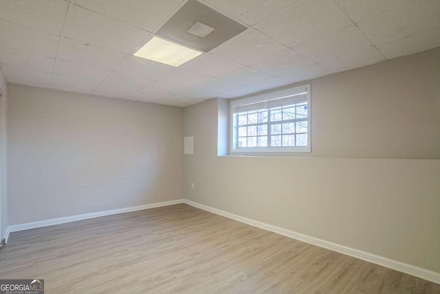 empty room with light hardwood / wood-style flooring and a drop ceiling