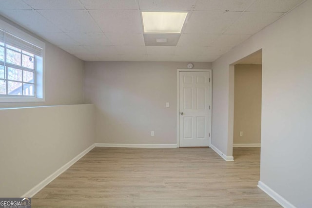 unfurnished room with a drop ceiling and light hardwood / wood-style flooring