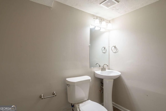 bathroom with toilet and a textured ceiling