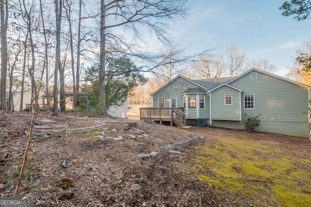 rear view of property with central AC unit and a deck