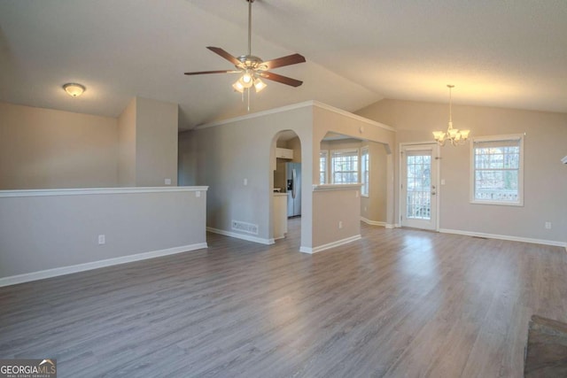 unfurnished living room with hardwood / wood-style flooring, vaulted ceiling, and ceiling fan with notable chandelier