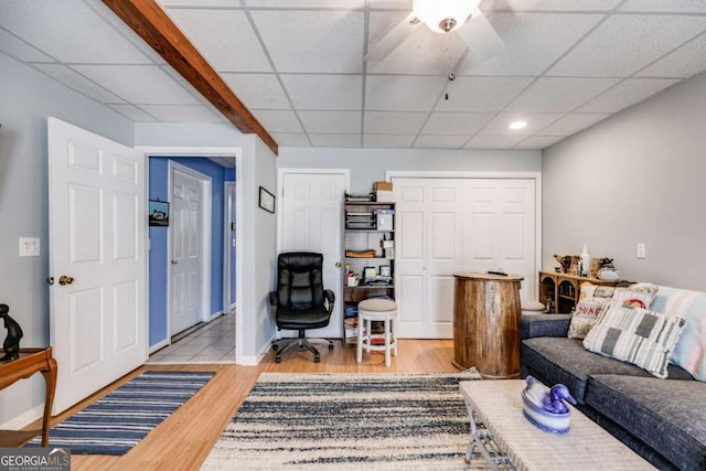 living room featuring a drop ceiling and light hardwood / wood-style floors