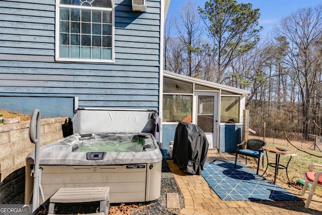 view of patio featuring grilling area, a sunroom, and a hot tub