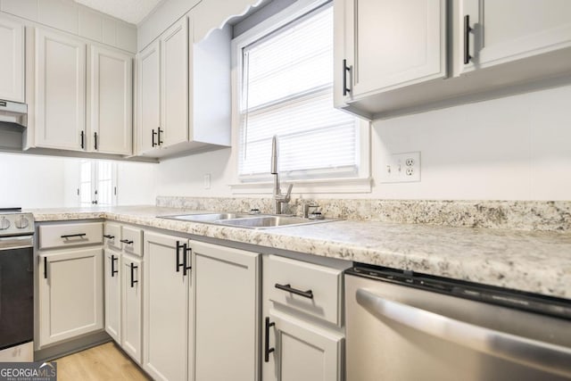 kitchen featuring stainless steel appliances, white cabinetry, sink, and light wood-type flooring