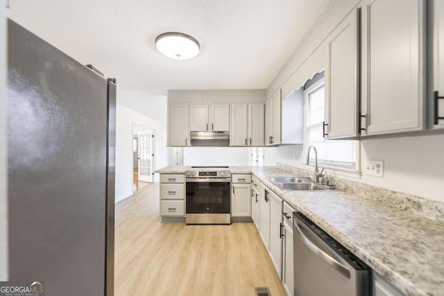 kitchen with sink, light wood-type flooring, and appliances with stainless steel finishes