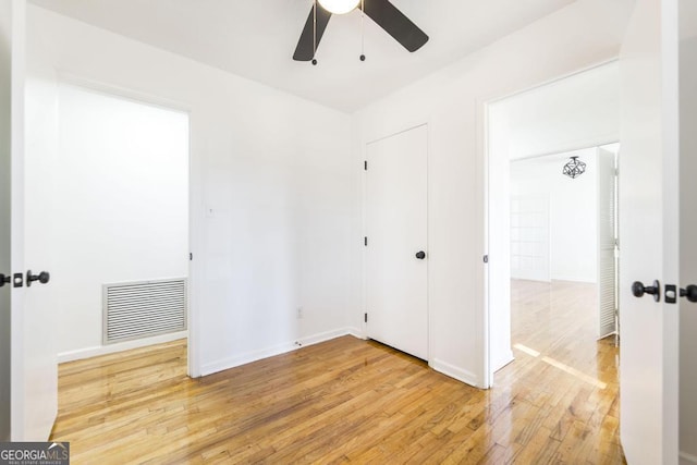 unfurnished bedroom featuring hardwood / wood-style floors, ceiling fan, and a closet