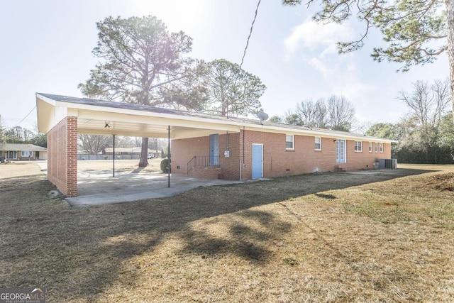 back of house with a carport, a yard, and cooling unit