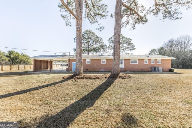 back of house with central AC, a carport, and a yard