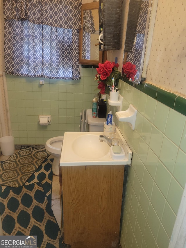 bathroom with vanity, tile patterned flooring, toilet, and tile walls