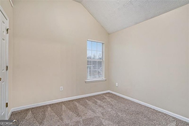 unfurnished room with lofted ceiling, carpet floors, and a textured ceiling