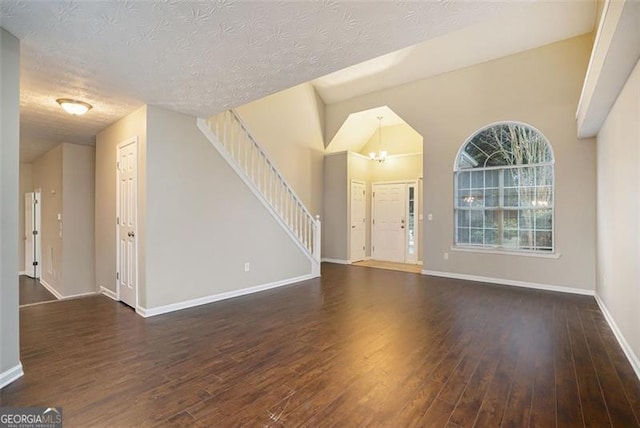 interior space with a notable chandelier, dark wood-type flooring, and a textured ceiling