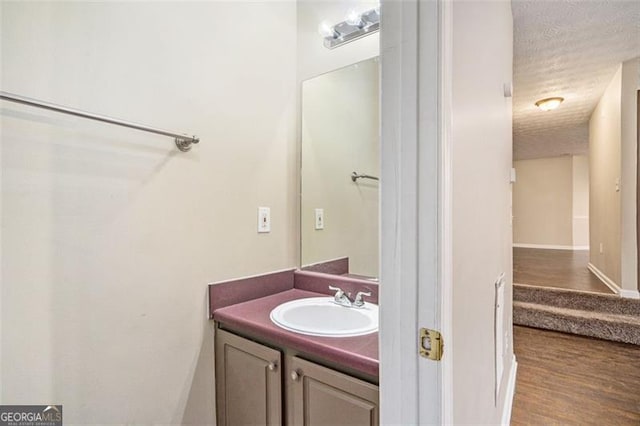 bathroom with vanity, hardwood / wood-style floors, and a textured ceiling