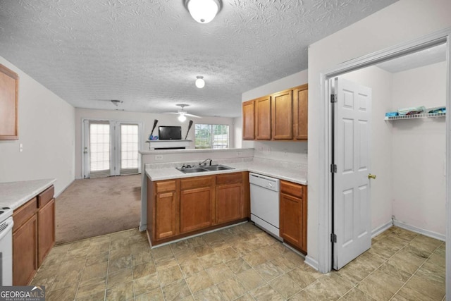 kitchen with sink, dishwasher, ceiling fan, light carpet, and kitchen peninsula