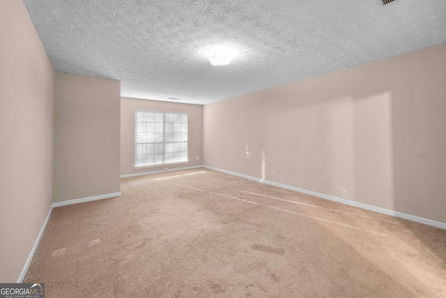 carpeted empty room featuring a textured ceiling