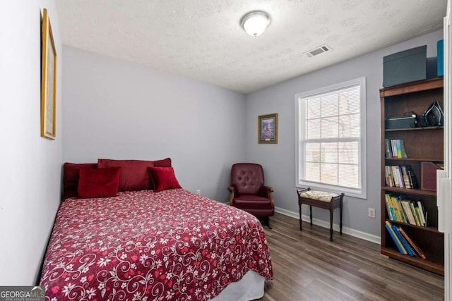 bedroom featuring hardwood / wood-style floors and a textured ceiling