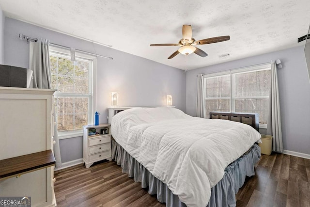 bedroom with ceiling fan, dark hardwood / wood-style floors, and a textured ceiling