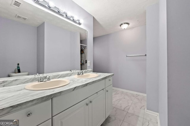 bathroom featuring vanity, toilet, and a textured ceiling