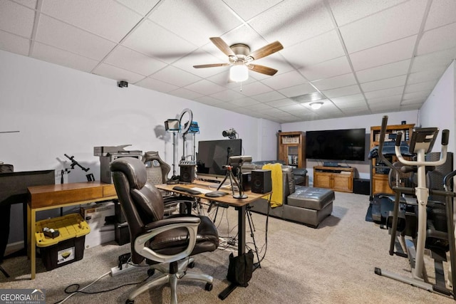 carpeted office space featuring a paneled ceiling and ceiling fan