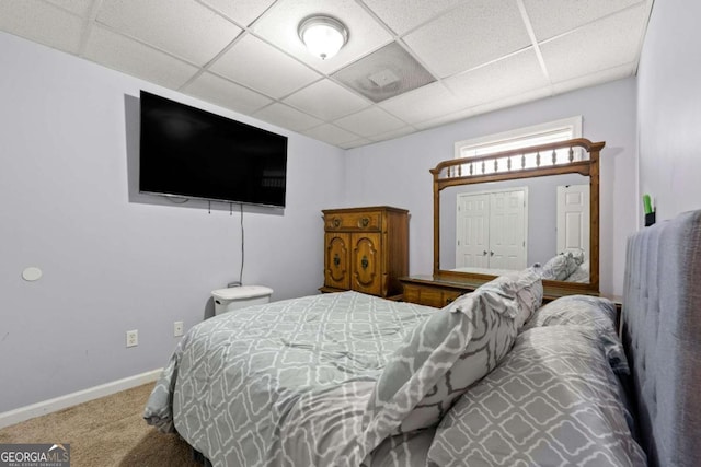 bedroom featuring carpet and a paneled ceiling