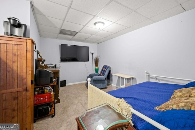 carpeted bedroom featuring a drop ceiling