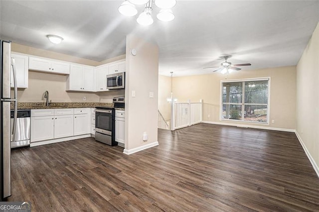 kitchen featuring appliances with stainless steel finishes, sink, white cabinets, and decorative light fixtures