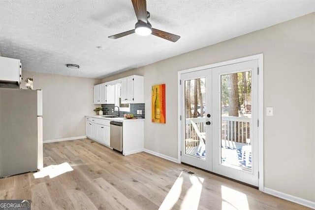 kitchen with french doors, appliances with stainless steel finishes, sink, and white cabinets