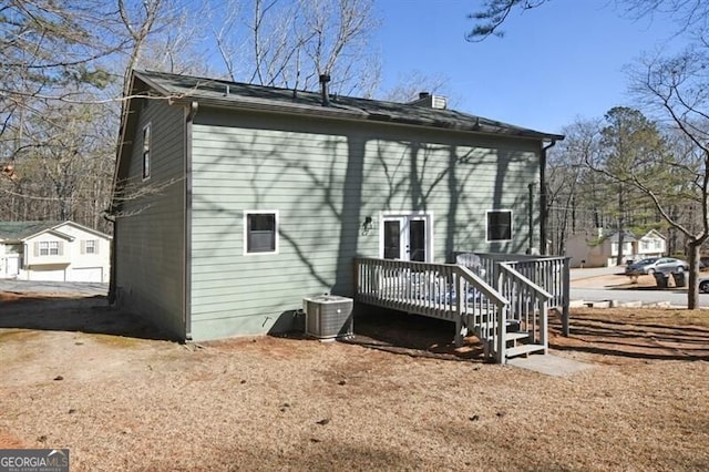 back of property with a wooden deck and central AC